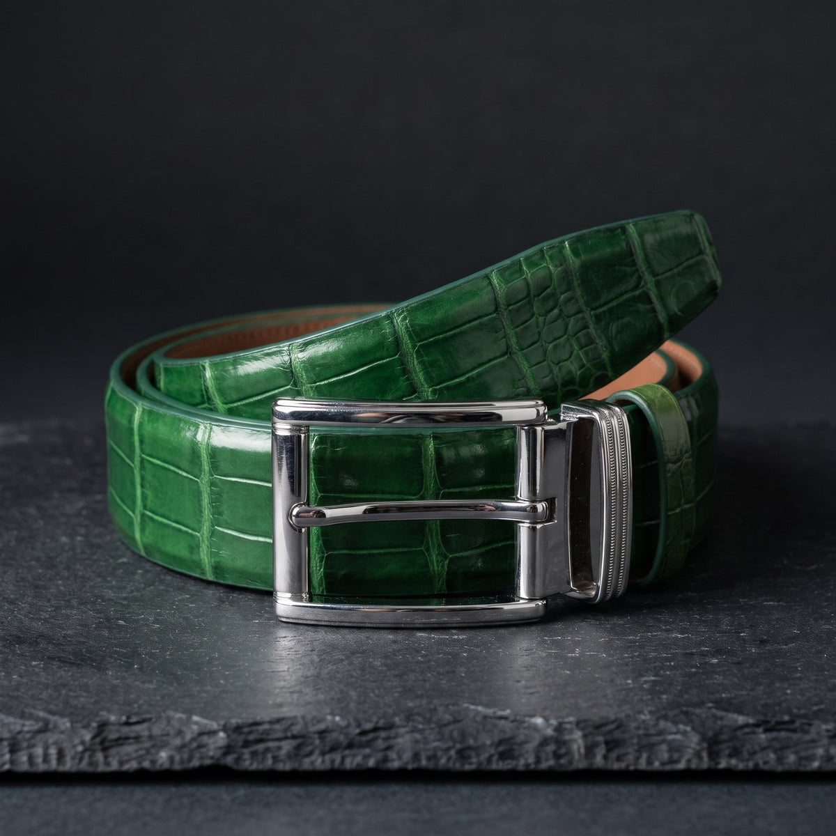Green Crocodile Belly Belt, rolled, on dark slate