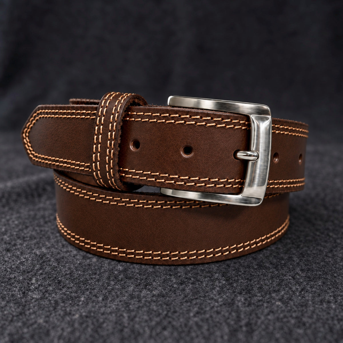 The Italian One-Piece belt in Brown, coiled on charcoal wool [Brown]