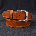 The Italian One-Piece belt in Cognac, coiled on charcoal wool [Cognac]