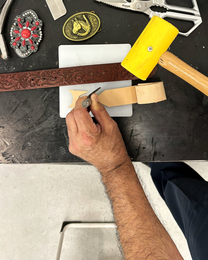 Cutting the red tooled strap to size at the bench