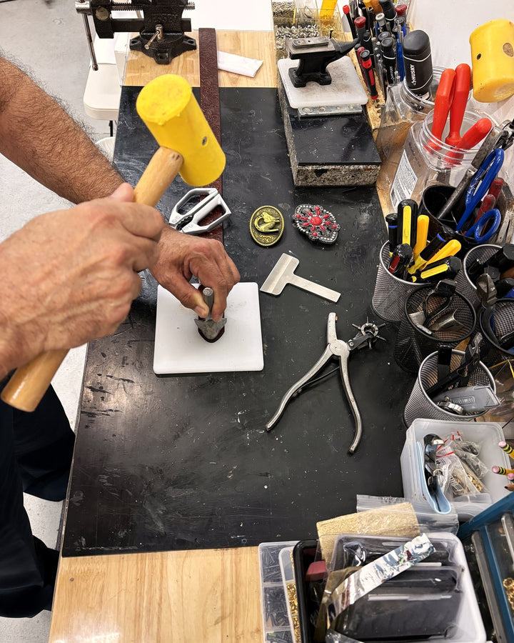A belt repair at the bench, mallet raised